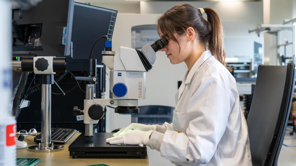 Prodrive Technologies engineer inspecteert printplaat onder Zeiss stereomicroscoop