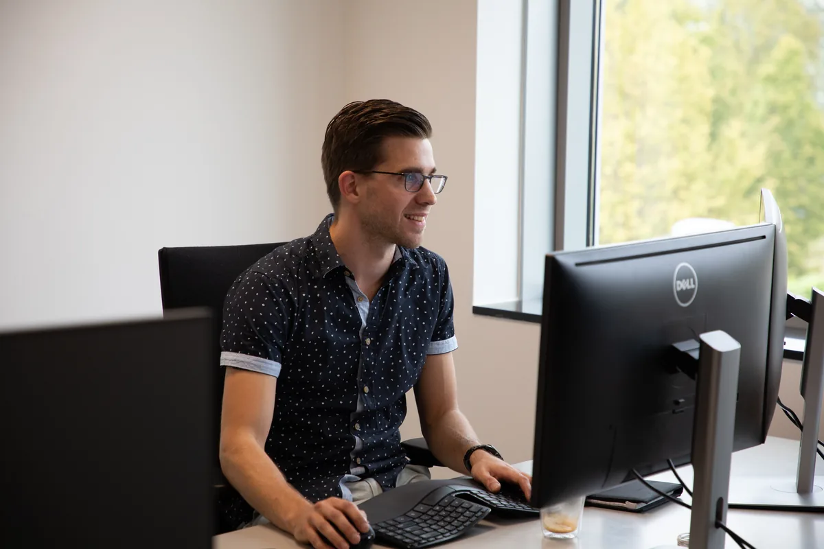 Prodrive Technologies software engineer werkt met twee monitoren op kantoor